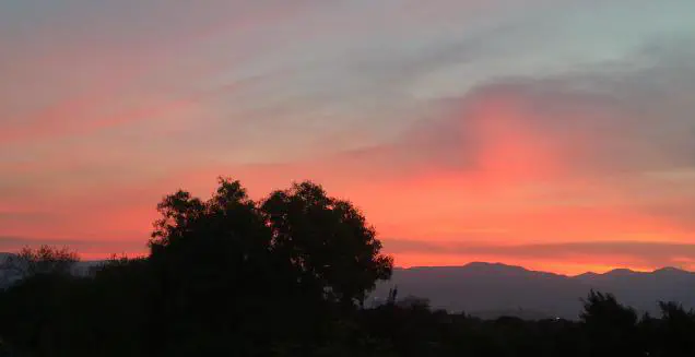 Sunset with peach tones in the sky and mountains in the background
